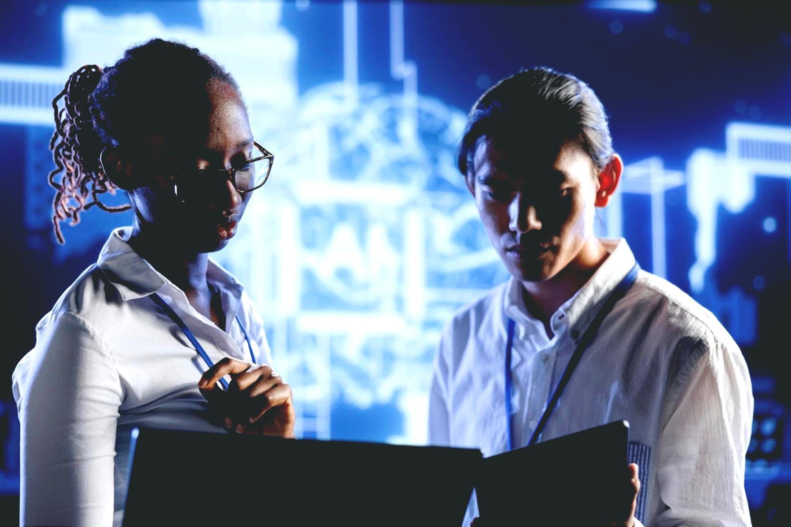 Students working on mobile game development projects in modern classroom setting